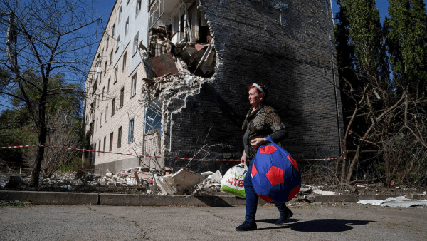 A woman evacuates her apartment building in the Donetsk region of Ukraine on Sept. 23 after the building was destroyed by a Russian attack. Funded by a $2.5 million Department of Defense award, a University of Maryland-led study seeks to determine the military factors that cause conflicts to conclude or to continue for years.  Photo by AP Photo/Evgeniy Maloletka